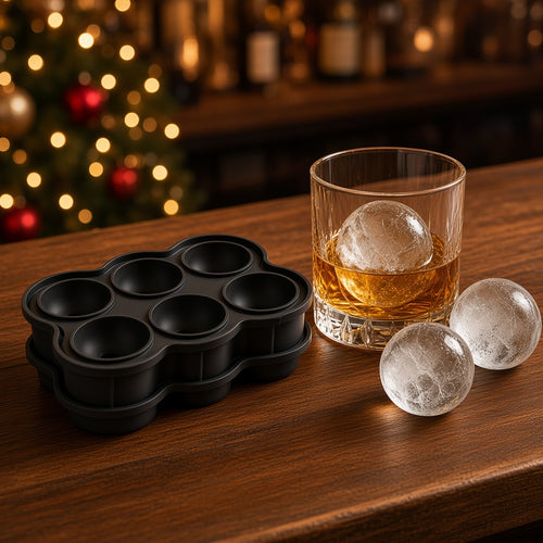 Clear ice spheres in cocktail glasses beside a black silicone ice ball mold